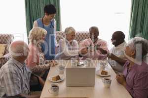 Senior people holding mobile phone at nursing home