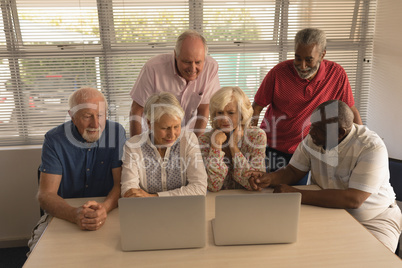 Group of senior people using laptop at nursing home