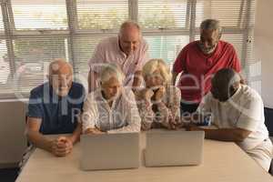 Group of senior people using laptop at nursing home