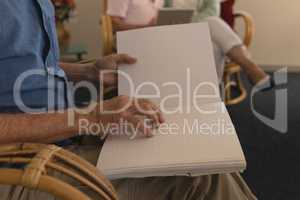 Blind senior man reading a braille book at nursing home