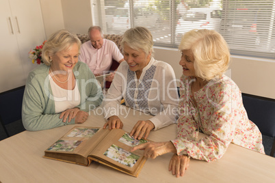Group of senior women looking at photo album at nursing home