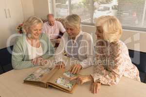 Group of senior women looking at photo album at nursing home