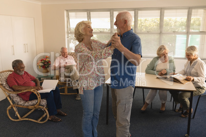 Active senior couple dancing at nursing home
