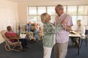 Active senior couple dancing at nursing home