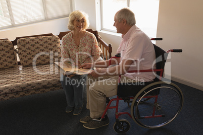Senior couple looking at photo album in living room