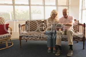 Senior couple using digital tablet in living room