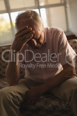 Worried senior man relaxing on sofa in living room