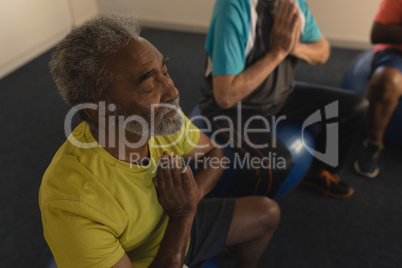 Senior men performing yoga at home