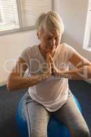 Senior woman performing yoga at home