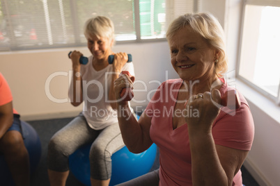 Senior women exercising with dumbbells at home