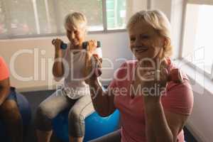 Senior women exercising with dumbbells at home