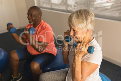 Senior people exercising with dumbbells at home