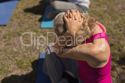 Senior woman performing yoga in the park