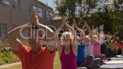 Senior group doing yoga together in the park