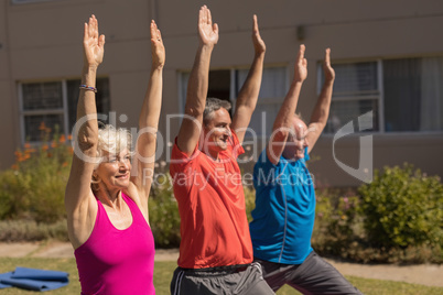 Trainer training senior people in performing exercise