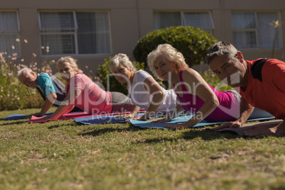 Trainer training senior people in performing exercise