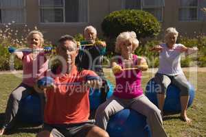 Trainer training senior people in performing exercise