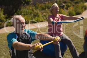 Senior man and woman exercising woman the