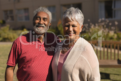 Senior couple standing in the park at nursing home