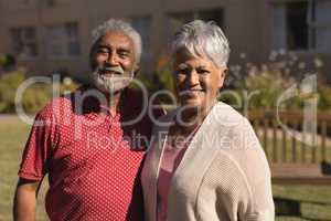 Senior couple standing in the park at nursing home