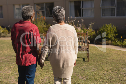 Senior couple standing hand in hand in the park of nursing home