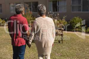Senior couple standing hand in hand in the park of nursing home