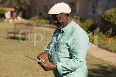 Senior man using digital tablet in the nursing park