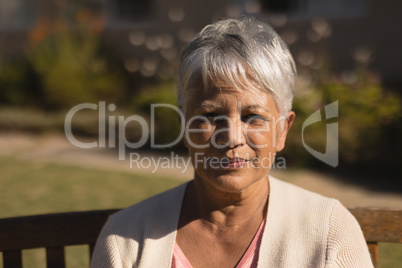 Senior woman sitting on a bench in the park