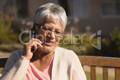 Senior woman talking on mobile phone in the park