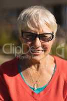 Senior woman in spectacle smiling in the park
