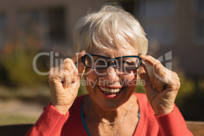 Senior woman in spectacle smiling in the park