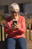 Senior woman using mobile phone in the park
