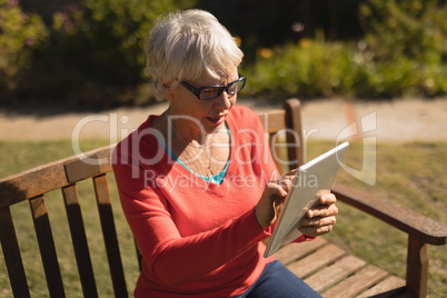Senior woman using digital tablet in the park