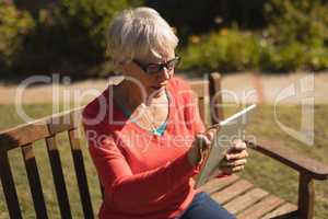 Senior woman using digital tablet in the park
