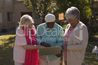 Senior people using laptop in the park