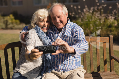 Senior couple taking selfie with mobile phone in the park