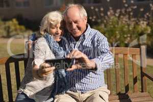 Senior couple taking selfie with mobile phone in the park