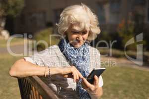 Senior woman using mobile phone in the park