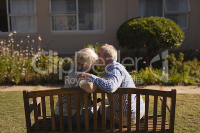 Senior man kissing senior woman in the park