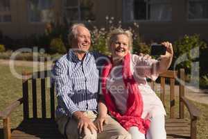 Senior couple taking selfie with mobile phone in the park