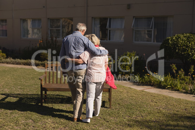 Senior couple standing with arm around in the park