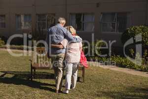 Senior couple standing with arm around in the park