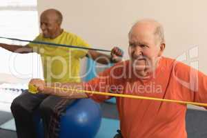 Senior man exercising with resistance band in fitness studio