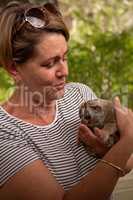 Woman in hooped shirt holding slow loris