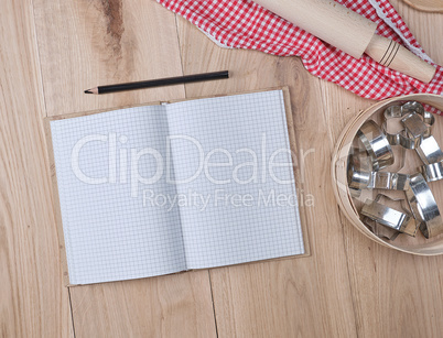 open notebook in a cell, round wooden sieve