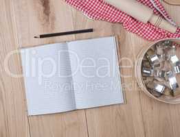open notebook in a cell, round wooden sieve