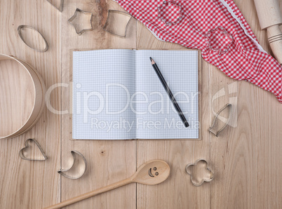 blank open notebook in line and wooden kitchen accessories