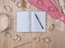 blank open notebook in line and wooden kitchen accessories