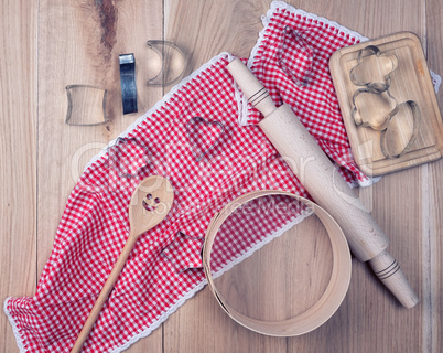 empty round wooden sieve and rolling pin on a red textile kitche