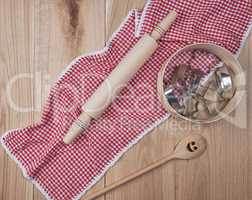 round wooden sieve and rolling pin on a red textile kitchen towe